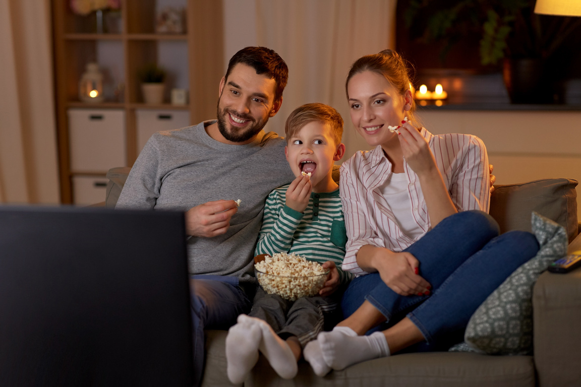 Happy Family Watching TV with Popccorn